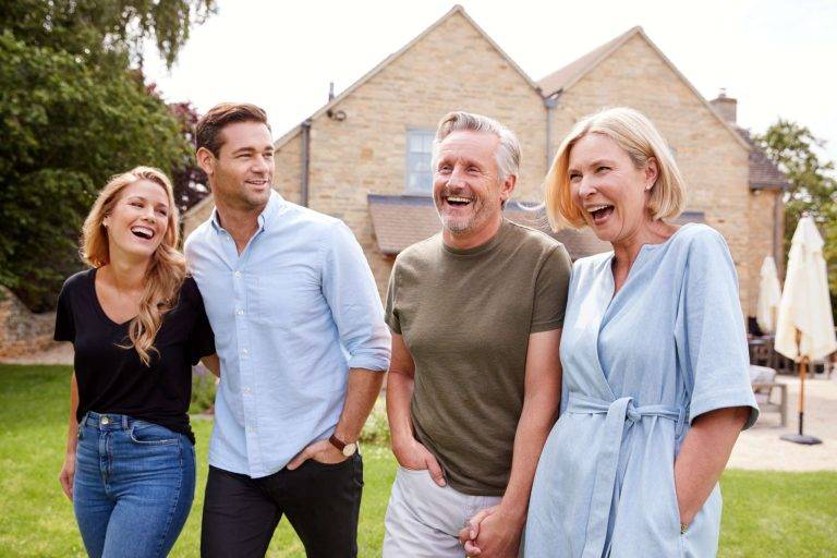 Lifetime Income Planning - Family With Senior Parents And Adult Offspring Walking And Talking In Garden Together