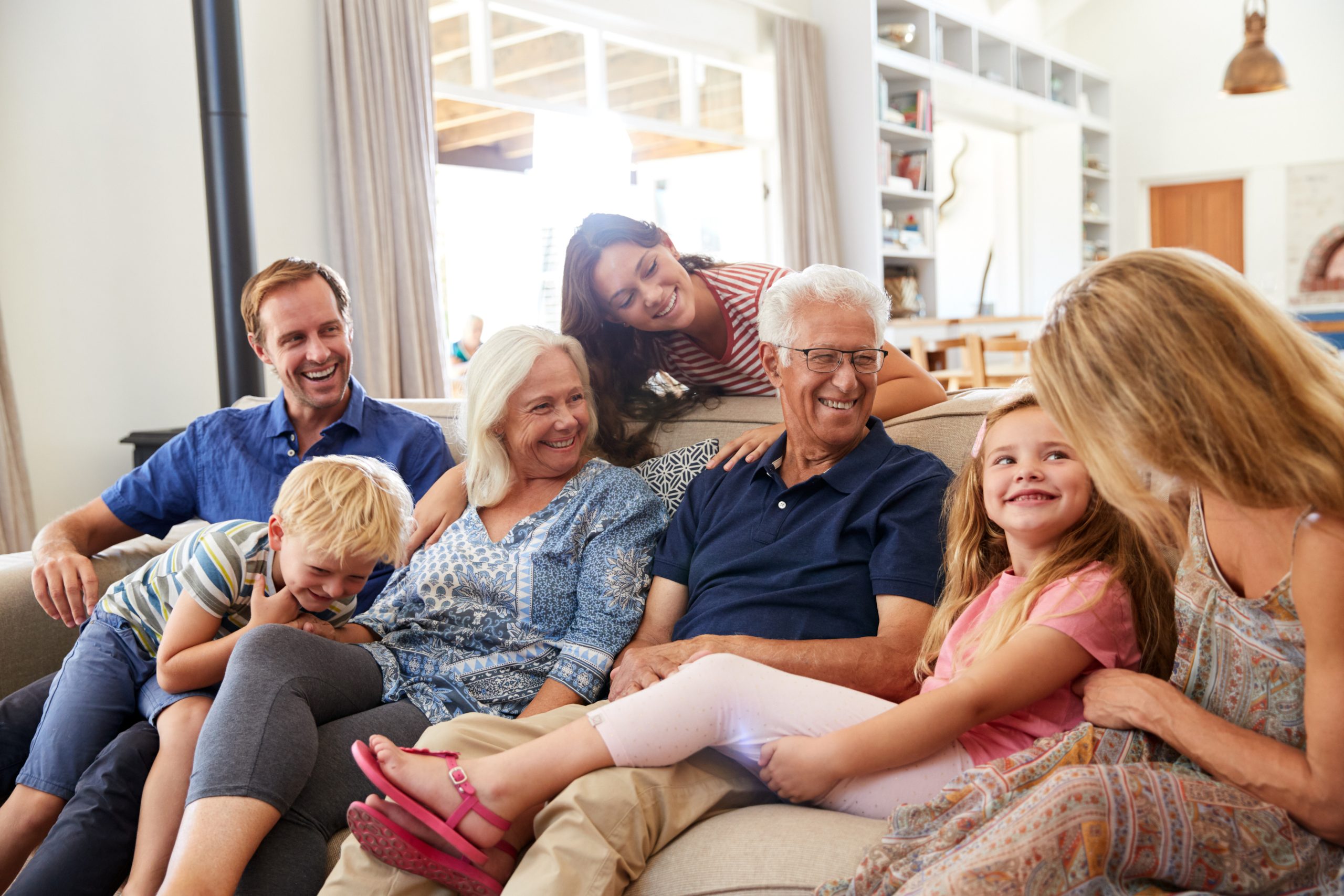 Older couple enjoying coffee on the front porch of their home while planning for aging in place during retirement. Multi-Generation Family Sitting On Sofa At Home Relaxing And Chatting Finding Purpose in Retirement | How to Make the Most of Your Time