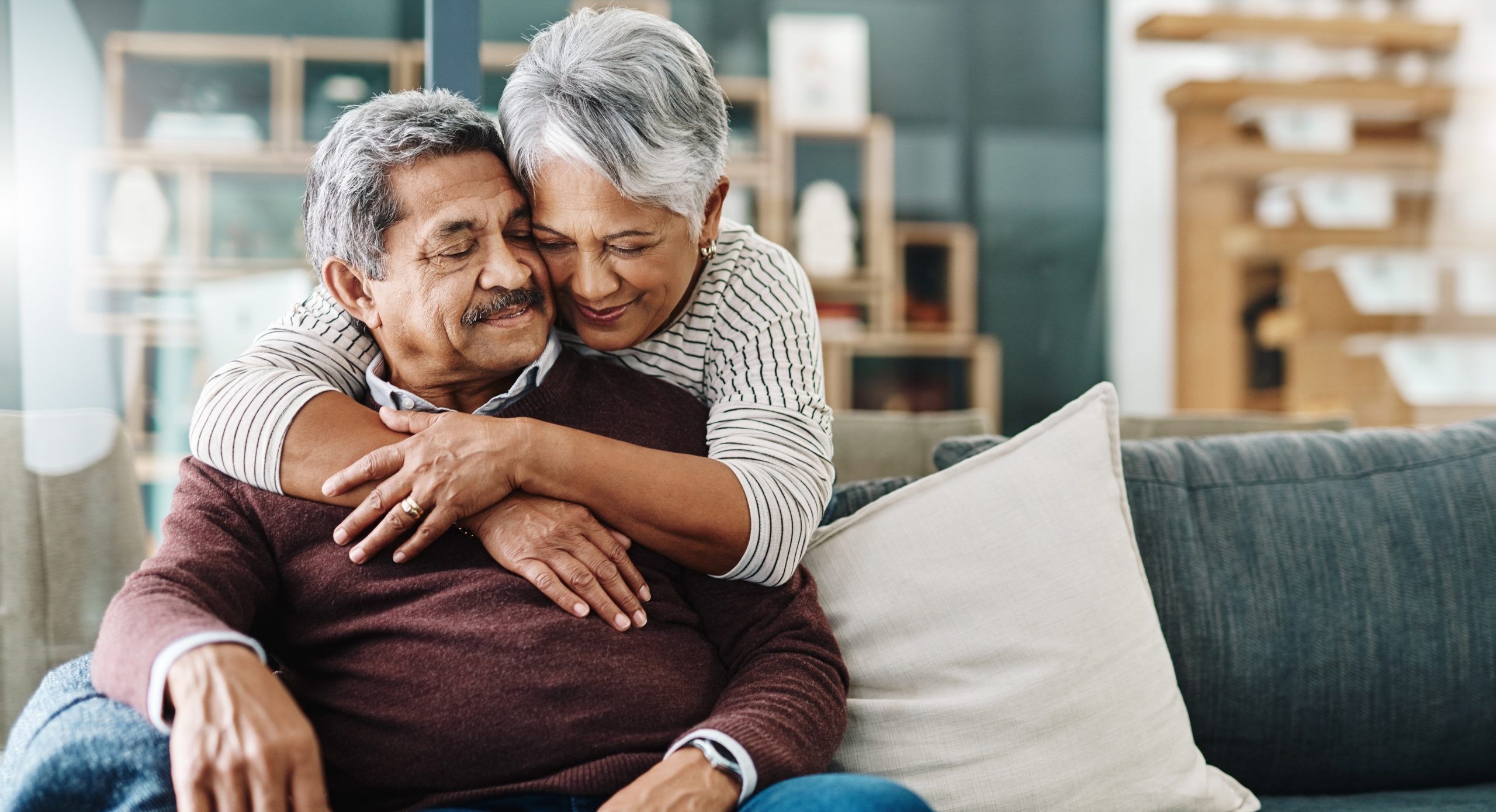 Cropped shot of a cheerful elderly woman hugging her husband who's in a wheelchair at home during the day